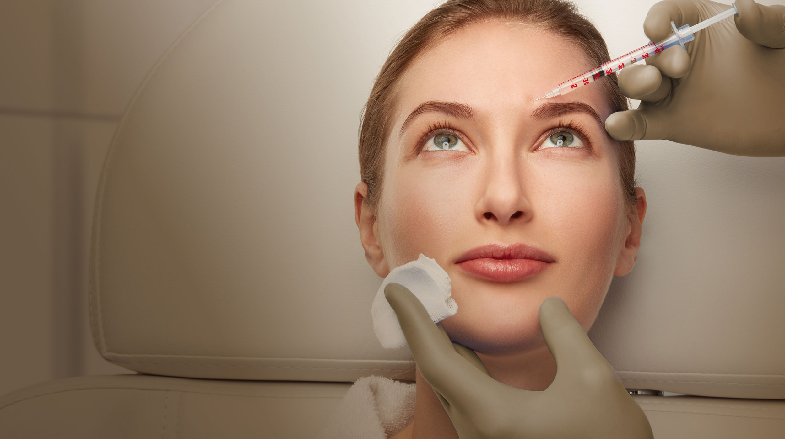 Close-up of a woman's face receiving an injectionin her forehead