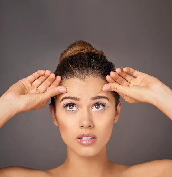 Portrait of a woman touching her forehead